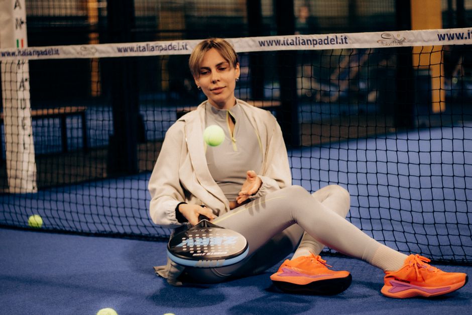 Vrouwelijke padelspeler in comfortabele sportieve leggings tijdens training op de baan.